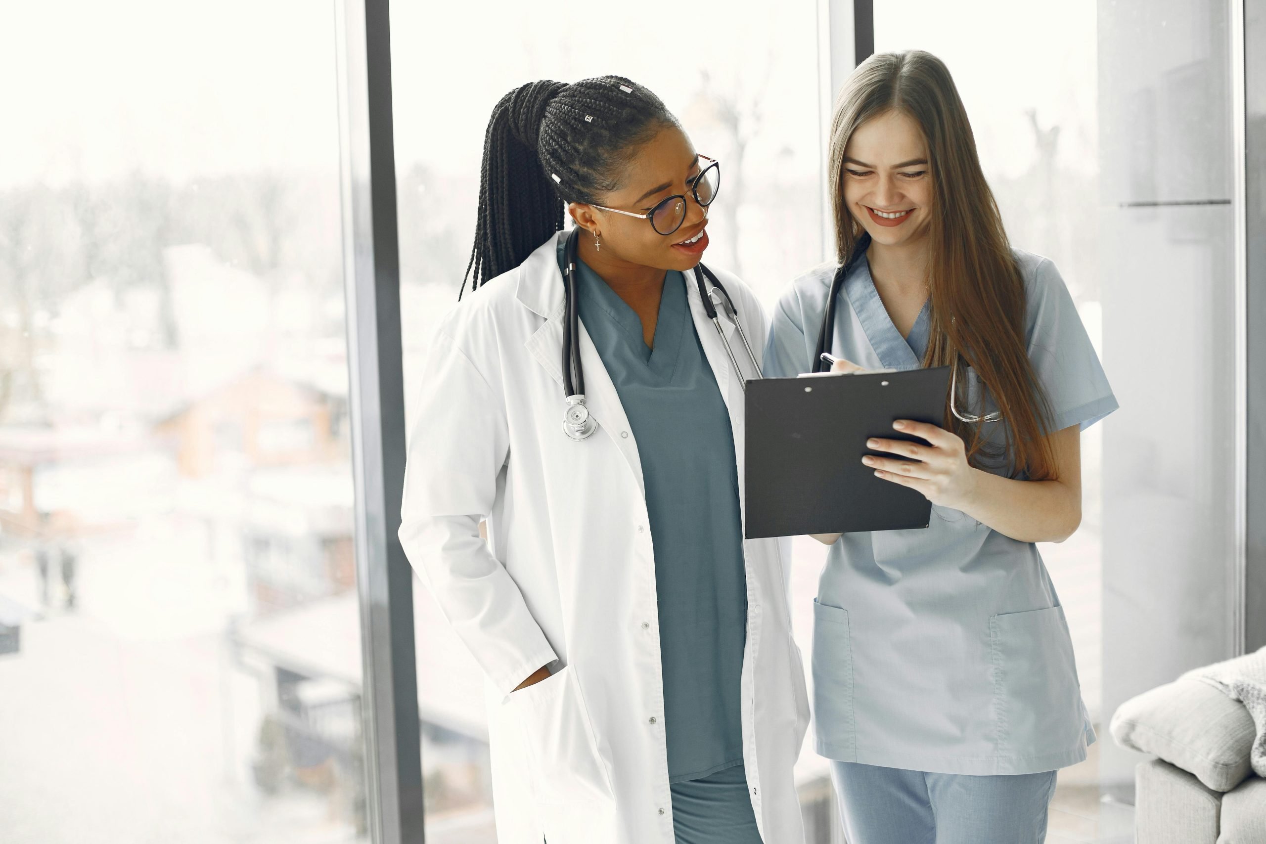Two young female doctors looking at a clipboard