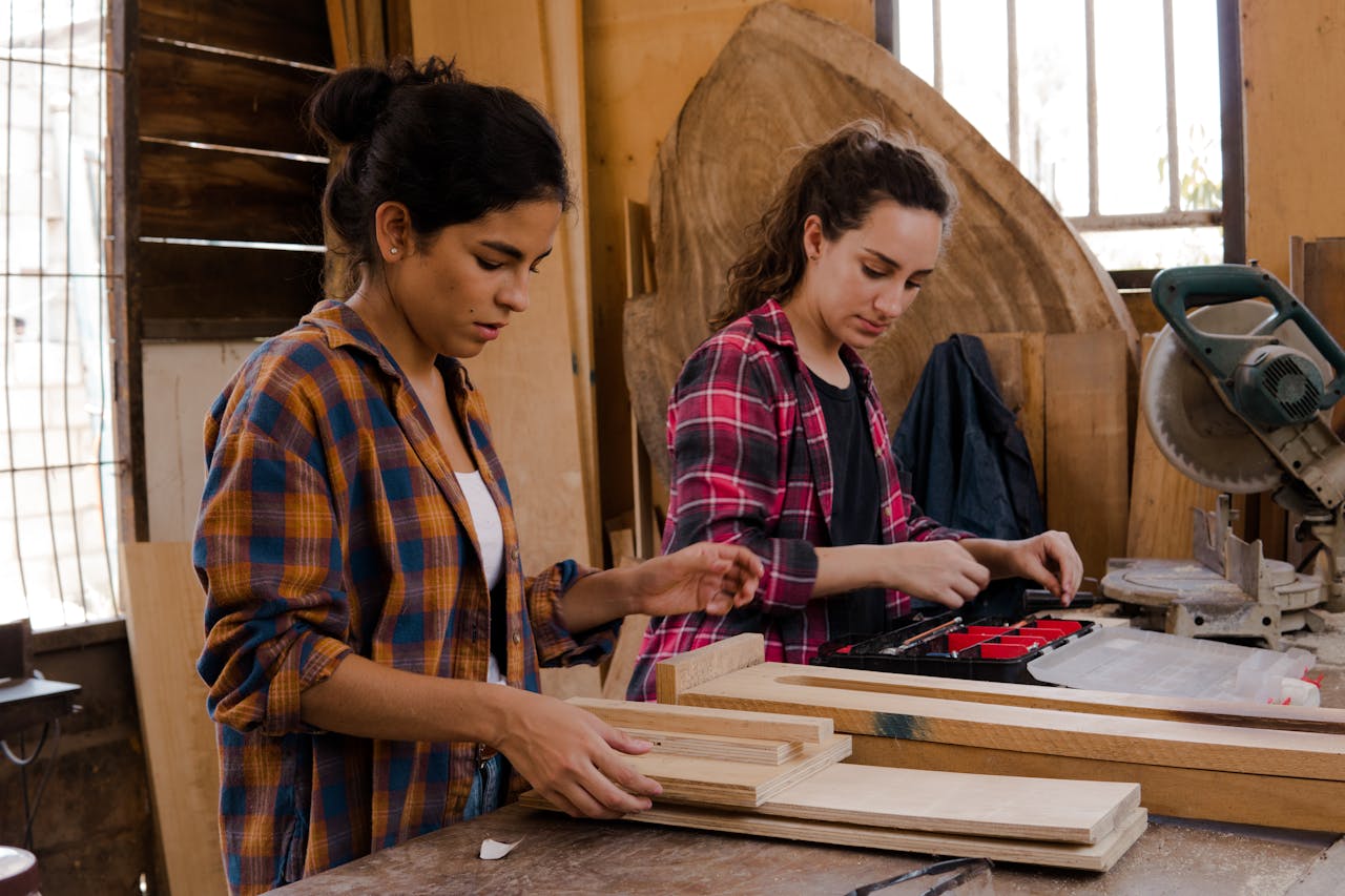 Two apprentices working in a woodworking workshop.